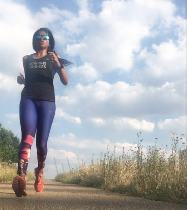 indian woman running in a green outdoor open space