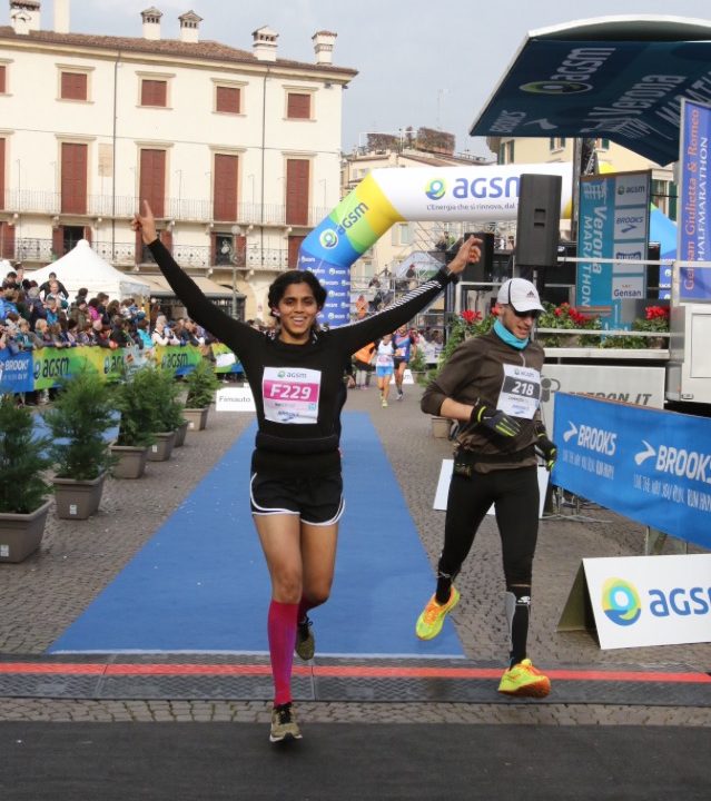 indian woman running through finish line